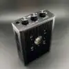 Compact audio amplifier with volume and tone controls, black metal design.